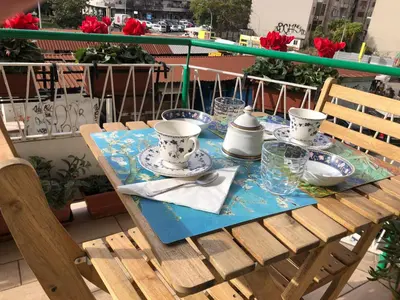 a table with plates and cups on top of a balcony at Questa casa non è un albergo CIU-ATR 9390-9 in Rome