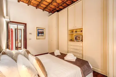 a bedroom with a large white bed and a dresser at FRESH HOUSE CAVOUR in Rome