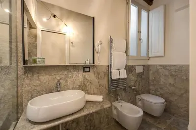 a bathroom with a sink and a toilet and a mirror at Residenze Argileto in Rome