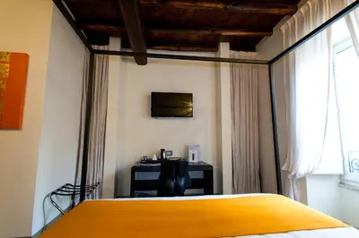 a bedroom with a yellow bed and a window at Residenze Argileto in Rome