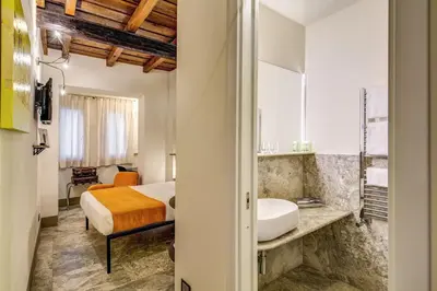 a bedroom with a bed and a bathroom with a sink at Residenze Argileto in Rome