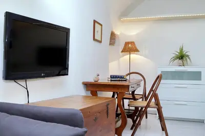 a living room with a tv and a table with a chair at Relax Chiavari House in Rome