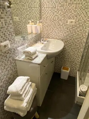 a bathroom with a sink and a mirror and towels at Relax Chiavari House in Rome