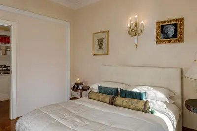 a bedroom with a white bed and a chandelier at Luxury Apt with Colosseum View in Rome