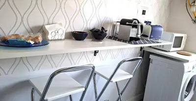 a kitchen with a counter with two chairs and a microwave at Casa Giustiniano - Metro San Paolo in Rome