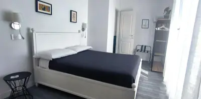 a bedroom with a bed in a white room at Casa Giustiniano - Metro San Paolo in Rome