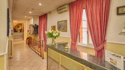a hallway with red curtains and a vase of flowers at Hotel Washington in Rome