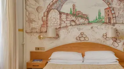 a bedroom with a bed with a painting on the wall at Hotel Washington in Rome