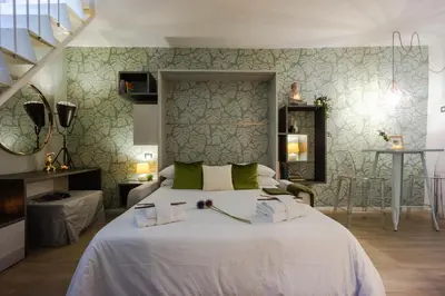 a bedroom with a large white bed and a staircase at Green Terrace Loft Colosseum in Rome