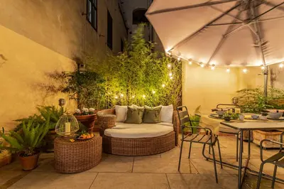 a patio with a couch and a table with lights at Green Terrace Loft Colosseum in Rome