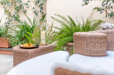 a patio with two wicker chairs and a candle at Green Terrace Loft Colosseum in Rome