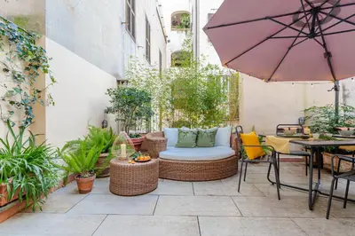 a patio with a table and chairs and an umbrella at Green Terrace Loft Colosseum in Rome