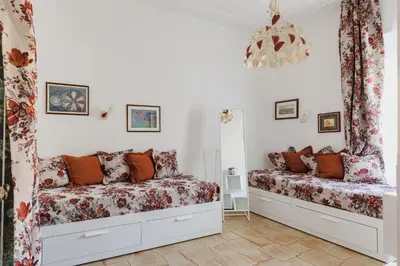 a bedroom with two beds and a chandelier at My Home in San Pietro in Rome