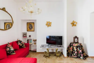 a living room with a red couch and a tv at My Home in San Pietro in Rome