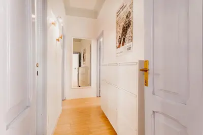 a hallway with white walls and a wooden floor at BBHOME Comfort apartment near Colosseum in Rome