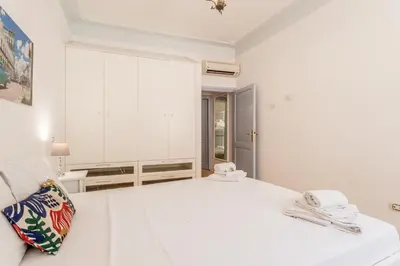 a white bedroom with a large white bed at BBHOME Comfort apartment near Colosseum in Rome