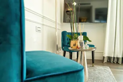a living room with a blue chair and a table at Monastero dei Santi in Rome