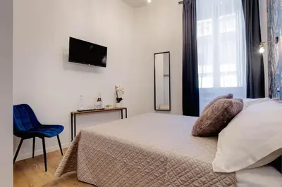 a bedroom with a bed and a chair and a window at The Venue Sistina in Rome