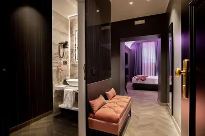 a bathroom with a couch and a bedroom with a bed at Hotel La Place Roma in Rome