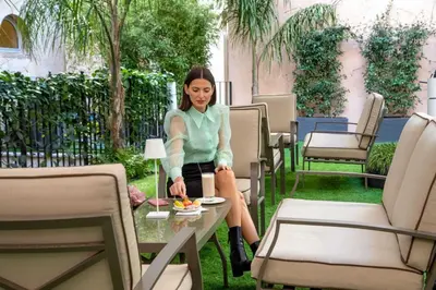 a woman sitting on a table with a plate of food at Hotel La Place Roma in Rome