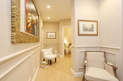 a hallway with two chairs and a painting on the wall at Daplace - Lucrezia Apartment in Rome
