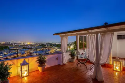 a balcony with a view of a city at night at Daplace - Terenzia Apartment in Rome