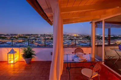 a balcony with a view of a city at night at Daplace - Terenzia Apartment in Rome