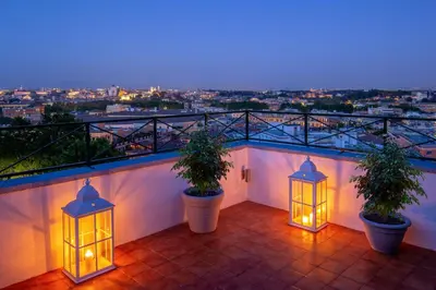 a balcony with two potted plants and lights at Daplace - Terenzia Apartment in Rome