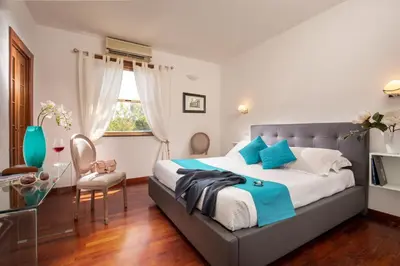 a bedroom with a large bed with blue pillows at Daplace - Terenzia Apartment in Rome