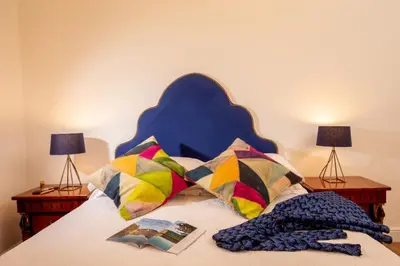 a bed with a blue headboard and pillows and two lamps at Daplace - Flaminia Apartment in Rome