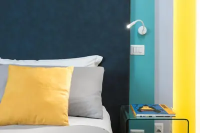 a bed with a yellow pillow and a side table at Circle in the Square in Rome