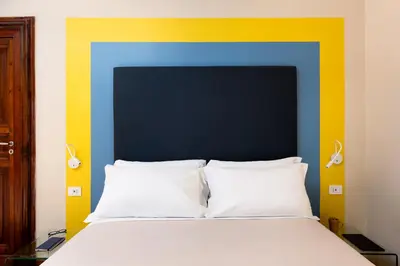 a bed with a blue and yellow head board at Circle in the Square in Rome