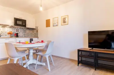 a living room with a white table and chairs and a tv at Domus Domi Barberini Sq. in Rome