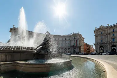 a fountain in the middle of a street with a building at Domus Domi Barberini Sq. in Rome