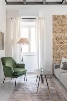 a living room with a green chair and a table at Saint Peter Elegant and Charming Apartment in Rome