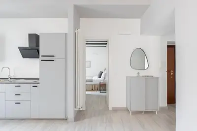 a white kitchen with a sink and a mirror at Saint Peter Elegant and Charming Apartment in Rome