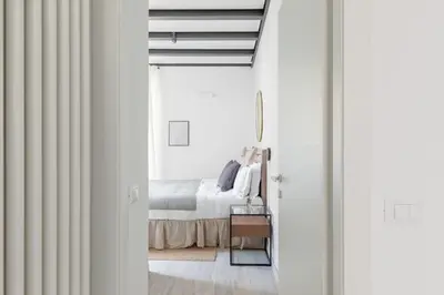 a white bedroom with a bed and a window at Saint Peter Elegant and Charming Apartment in Rome