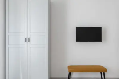 a chair in front of a wall with a television at Saint Peter Elegant and Charming Apartment in Rome
