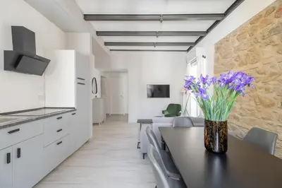 a kitchen and living room with a table and purple flowers at Saint Peter Elegant and Charming Apartment in Rome