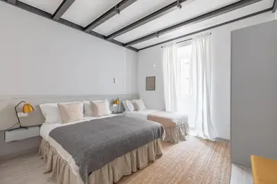 two beds in a bedroom with white walls and windows at Saint Peter Elegant and Charming Apartment in Rome