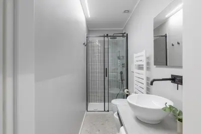 a white bathroom with a sink and a shower at Saint Peter Elegant and Charming Apartment in Rome