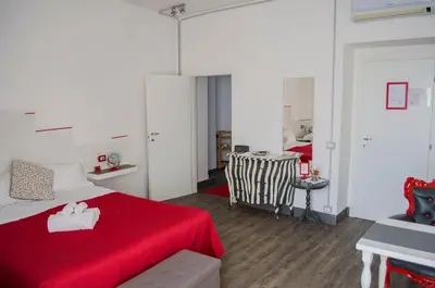 a bedroom with a red bed and a table at Relais Cola Di Rienzo in Rome
