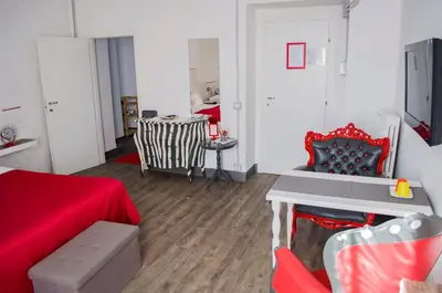 a living room with a red couch and a table at Relais Cola Di Rienzo in Rome