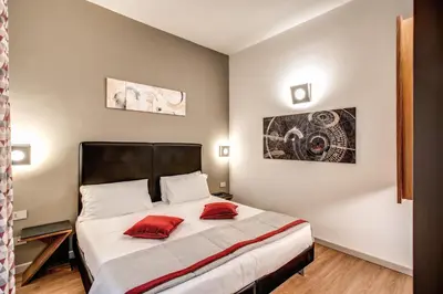 a bedroom with a bed with two red pillows on it at Maison Ripetta in Rome