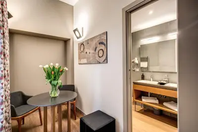 a bathroom with a table with a vase of flowers at Maison Ripetta in Rome