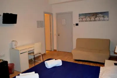 a bedroom with a bed and a desk and a chair at Check-Inn Rooms in Rome