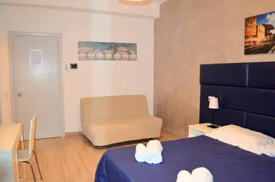 a hotel room with a bed and a chair and a chair at Check-Inn Rooms in Rome