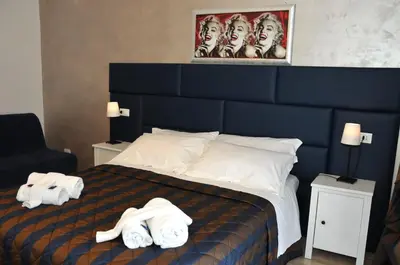 a hotel room with a bed with towels on it at Check-Inn Rooms in Rome