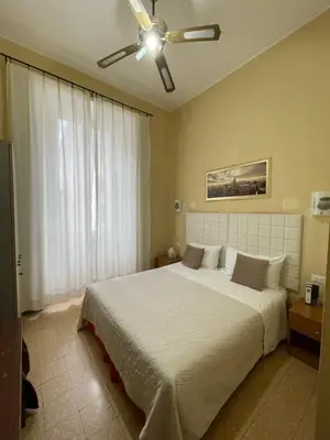 a bedroom with a large bed with a ceiling fan at Guest House Meret in Rome