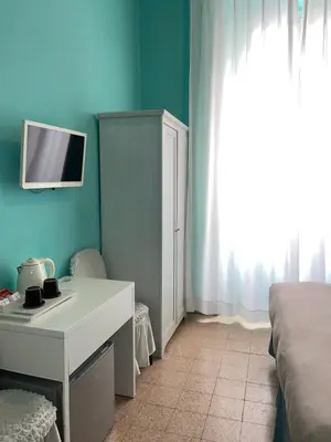 a bedroom with a desk and a bed with a tv on the wall at Guest House Meret in Rome